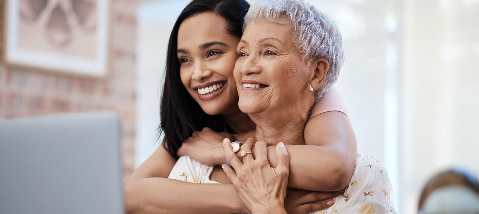 Daughter hugging mother in assisted living