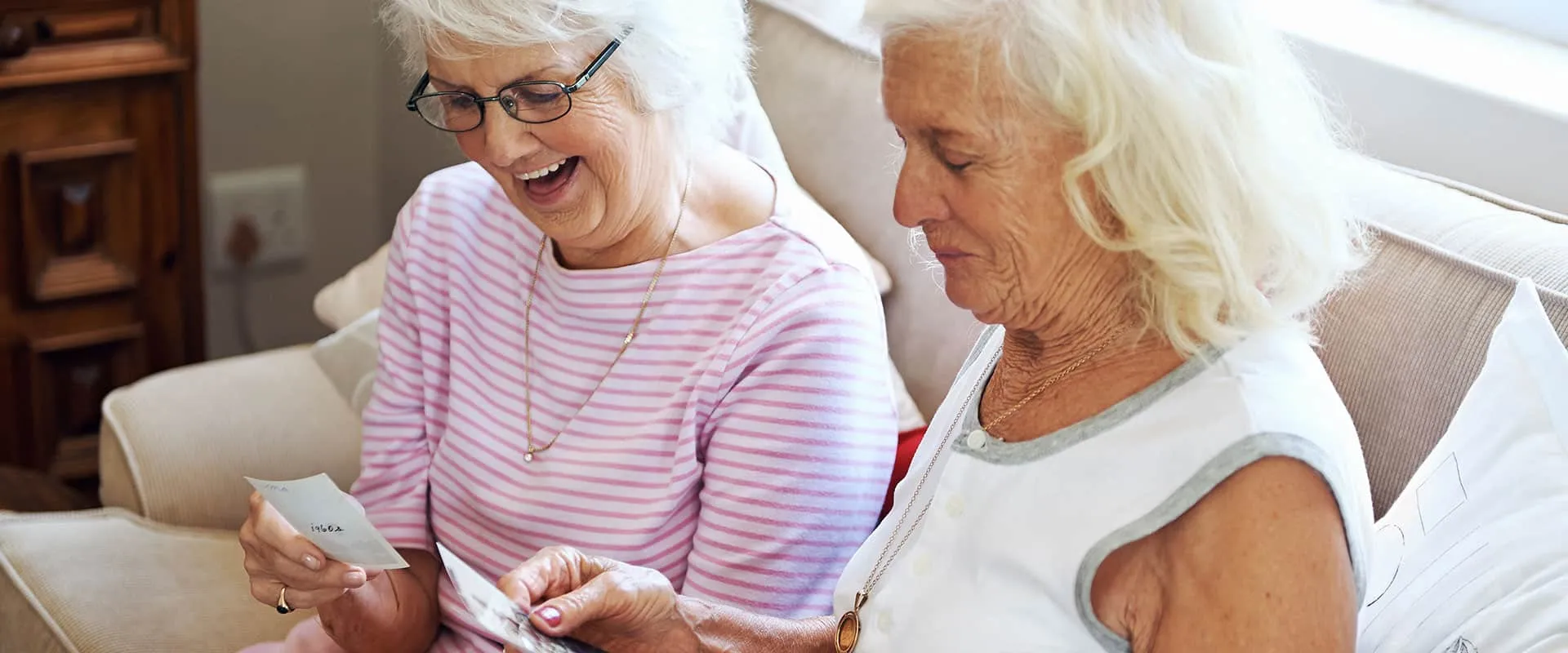 Memory care — women looking at photos together