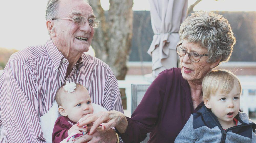 Grandmother and Grandfather Holding Child on Their Lap