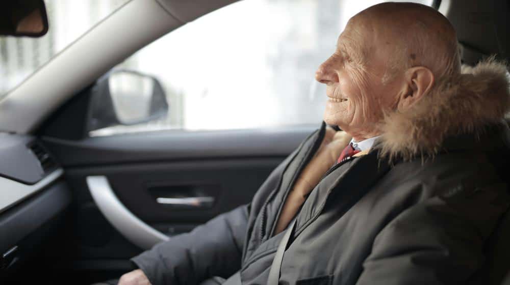 Smiling senior man in modern car | best vacations for seniors with limited mobility px featured image