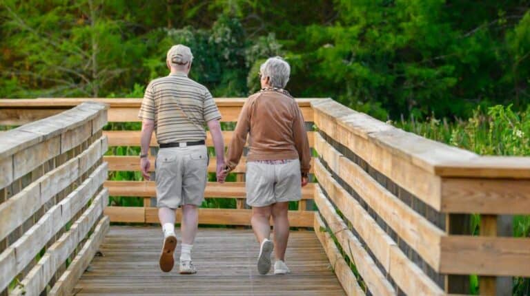 a couple of people that are walking across a bridge | STD seniors us featured image