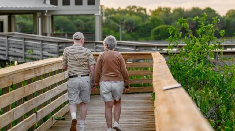 a couple of people that are walking on a bridge | affordable housing us featured image