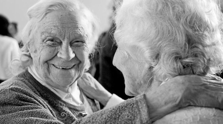 grayscale photo of woman in sweater smiling | Medicare Fraud us featured image