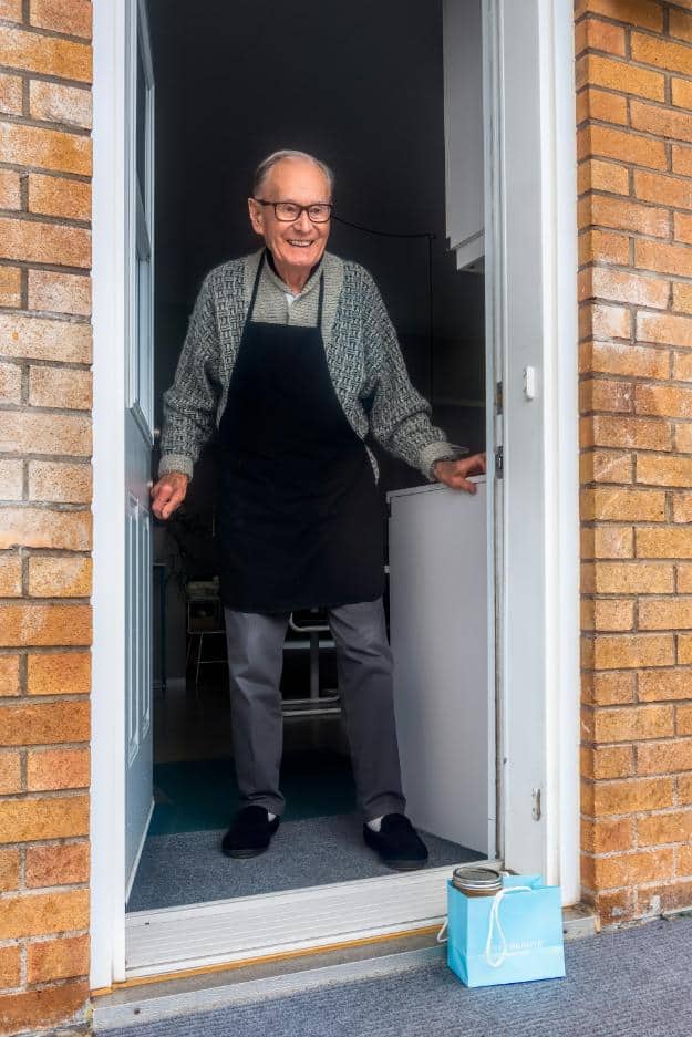 man in black vest and black dress pants standing beside white wooden door | questions to ask assisted living us