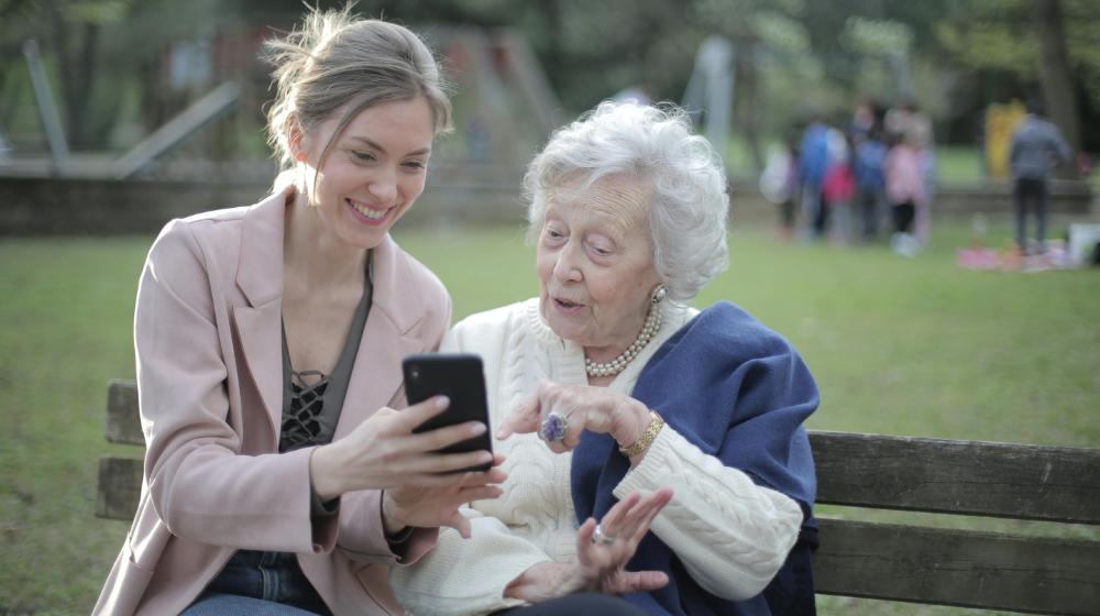 Cheerful senior mother and adult daughter using smartphone together | Black Friday Gift Ideas for Seniors px featured image