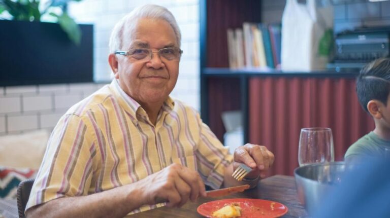 An Elderly Man in Yellow Striped Shirt Smiling while Holding a Knife and Fork | Hot Meals for Seniors px